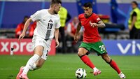 Spieler von Portugal und Slowenien im Zweikampf während eines Fußballspiels.