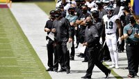 Ein American Football Trainerteam der Philadelphia Eagles steht an der Seitenlinie und beobachtet das Spielgeschehen.