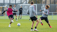 Fußballspieler trainieren Passspiel und Technik auf dem Trainingsplatz mit Leibchen