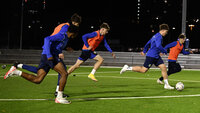 Hohes Pressing im Training: Spieler sprinten im Gegenpressing auf Kunstrasen (Nacht)
