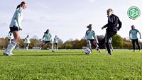 Spielerinnen der DFB-Auswahl trainieren unter Anleitung einer Trainerin auf einem Fußballplatz.