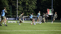 Jugendspieler des NEC Nijmegen trainieren auf dem Fußballplatz mit Ball und Leibchen.