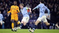 Zwei Fußballspieler kämpfen um den Ball während eines Spiels.