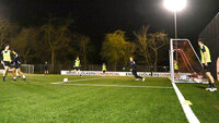 Fußballtraining bei Nacht auf Kunstrasenplatz unter Flutlicht mit mehreren Jugendspielern