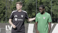 Ein Trainer spricht mit einem Spieler während einer Fußball-Trainingseinheit.