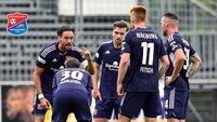 Fußballspieler der SpVgg Unterhaching stehen in einer Besprechung auf dem Spielfeld.