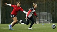 Fußballspielerinnen trainieren Zweikampf und Ballkontrolle auf einem Rasenplatz.