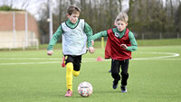 Seitliches 1 gegen 1 im E-Junioren-Training: Dribbling mit engem Verteidigerdruck auf Kunstrasen