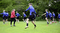 Jugendfußballer absolvieren Koordinationsübungen mit Hütchen auf dem Trainingsplatz