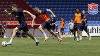 Fußballspieler sprinten mit Ball während eines Trainingsspiels im Stadion.