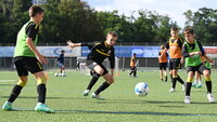 Jugendspieler trainieren auf einem Fußballplatz in einer intensiven Spielform.