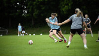 Fußballspielerinnen im intensiven Zweikampf während eines Trainingsspiels.