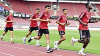 Fünf Spieler des 1. FC Nürnberg laufen beim Training im leeren Stadion über den Rasen.