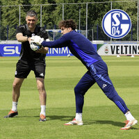 Torwart und Trainer Volkan Ünlü vom FC Schalke 04 halten gemeinsam einen Ball auf dem Trainingsplatz.