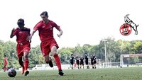 Zwei Jugendspieler des 1. FC Köln sprinten im Training auf dem Fußballplatz dem Ball hinterher