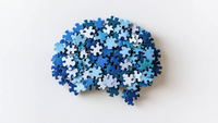 Ein Haufen blauer Puzzleteile liegt auf einer weißen Oberfläche.