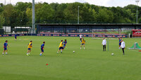 Fußballtraining in der Red Bull Akademie: Jugendspieler absolvieren eine Spielform auf dem Rasen, während Trainer zusehen.