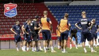 Fußballteam versammelt sich zur Besprechung auf dem Spielfeld im Stadion.