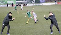 Ein Offensiv- und ein Defensivtrainer coachen eine Spielszene auf dem Fußballplatz.