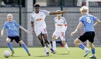 Eine Person schiebt einen riesigen Fußball einen Hügel hinauf, vor einem dramatischen Himmel.