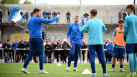 Trainer erklärt Fußballspielern der TSG Hoffenheim eine Übung auf dem Trainingsplatz.