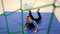 Die Szene zeigt spielerisches Kopfballtraining mit Spaßfaktor und Bewegungsfreude in der Halle.