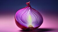 Eine halbierte rote Zwiebel liegt auf einem beleuchteten Untergrund vor dunkelviolettem Hintergrund.